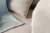 Beżowa sofa PUFLO Velvet z poduszkami i kocem.png